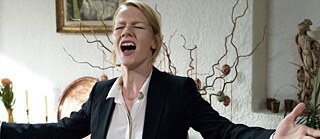 Blonde Frau schreit mit offenen Armen