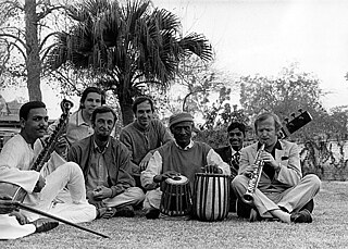 Gruppe von Musikern mit Zidar und Flöten vor Palmen auf dem Boden sitzend