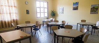 Ein Klassenraum, mit sechseckigen Tische sowie Stühlen, ohne Personen