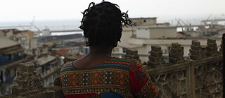 Aïcha schaut auf einer Terrasse in Alger Richtung Hafen 