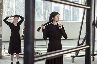 Junge Frauen bewegen sich in einem industriellen Umfeld. 