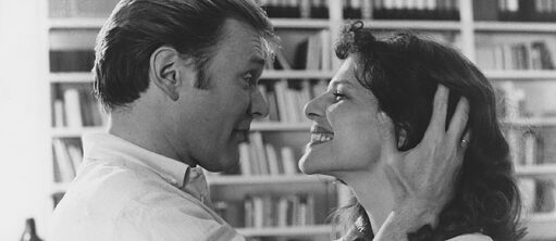 Szene vom Film Malou, in dem ein Mann und eine Frau sich lächelnd in die Augen schauen.