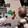 Two people in front of a commemorative plaque in Berlin for the Congo Conference.