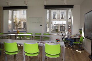 Der Umzug wurde auch für eine Modernisierung des Arbeitskonzeptes genutzt: Anstelle von Einzelbüros gibt es nun flexible Arbeitsplätze und Kreativbüros, in denen die Mitarbeiter*innen abteilungsübergreifend zusammenarbeiten. Wer dennoch seine Ruhe braucht, kann dank mobiler Arbeit zum Arbeiten auch einen der Klassenräume nutzen.