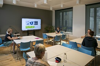 Work meeting in the classroom: to ensure rooms are optimally used, they often serve multiple purposes. This classroom generally filled with language learners is also a conference room. 