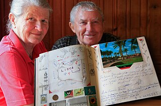 The Kreidls hold up their guest book with entries from around the world.
