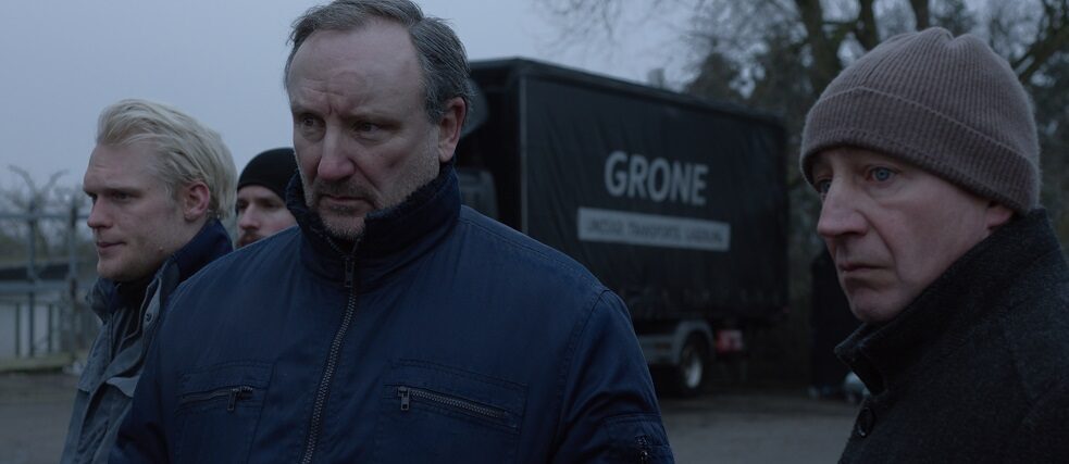 Atlas Vier Männer mit winterlicher Kleidung stehen vor einem LKW