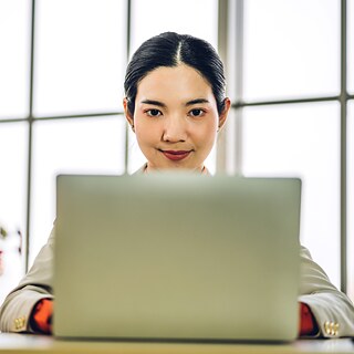 eine Frau vor einem Laptop sitzend