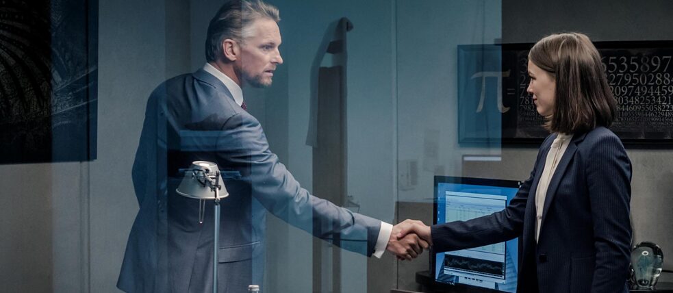 Jana Liekam (Paula Beer) and Gabriel Fenger (Barry Atsma) shake hands in Fenger's office.