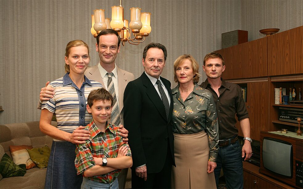 <b>Weissensee</b><br><i>Weissensee</i> ist eine Serie über den Niedergang der DDR und über zwei Familien in Ost-Berlin, die gegensätzlicher nicht sein könnten: Während eine Familie stramm regimetreu für die Stasi arbeitet, zählt sich die andere zum kritischen Milieu. Es geht um Liebesbeziehungen zwischen den zwei Angehörigen zweier grundverschiedener Familien, Verrat, Gier, Kampf und Macht. Doch<i>Weissensee</i> ist auch Politthriller, bei dem die deutsche Geschichte vor, während und nach der Wiedervereinigung eine wichtige Rolle spielt.