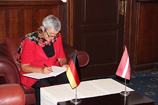 Carola Lentz signing the guest book of the Occupation Museum in Riga. 
