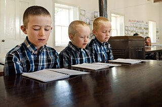 Traditionelle Mennoniten-Jungen lernen in einer Sonntagsschule während ihre Eltern in der Kirche nebenan den sonntäglichen Gottesdienst besuchen.