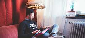 Fynn sitzt mit Synthesizer auf der Couch