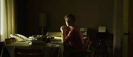 Szene vom Film "Exil" mit Frau am Schreibtisch in dunklem Zimmer