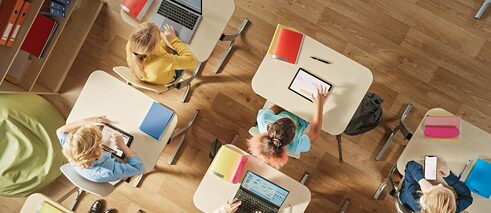 Students with digital devices in a classroom