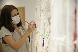 Ziyaretçiler perdeye malzemeleri tutturuyor.