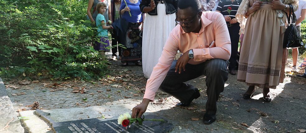 Vekull Rukoro (Autoridade Tradicional dos Ovaherero) coloca flores no memorial às vítimas do domínio colonial alemão sobre a atual Namíbia, no cemitério Garnison, em Berlim, em 7 de julho de 2015.