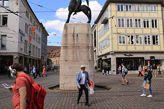 Fußgänger*innen gehen über die Straßenbahngleise in der Nähe des Bertoldsbrunnen