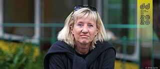 Ein Foto von Ines Geipel, die in die Kamera guckt und eine Sonnenbrille auf dem Kopf trägt.