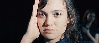 Eine junge Frau schaut direkt in die Kamera