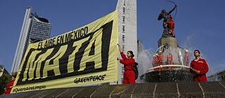 Aktivistinnen von Greenpeace halten ein Schild mit der spanischen Aufschrift „Die Luft in Mexiko tötet“.