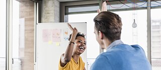 eine Frau und ein Mann klatschen sich in die Hände