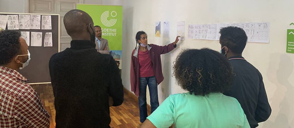 Uma participante do workshop apresenta a sua banda desenhada ao grupo.