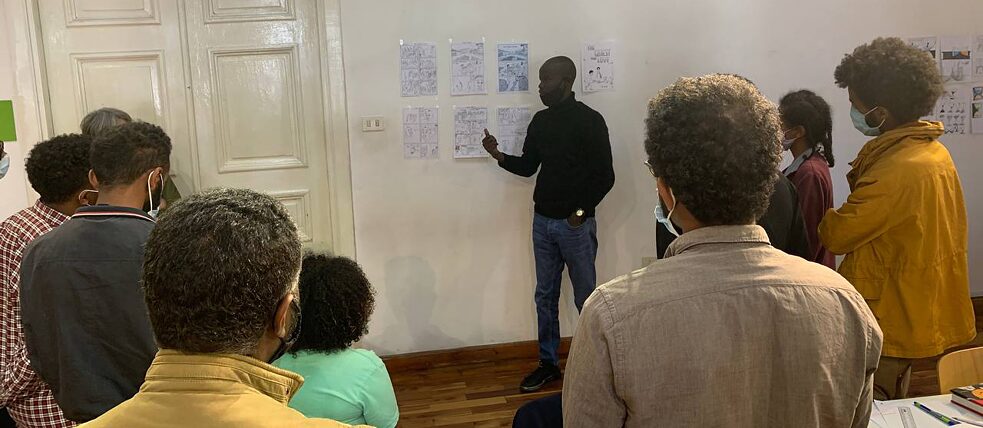 Ein Workshop-Teilnehmer erklärt der Gruppe seinen Comic.