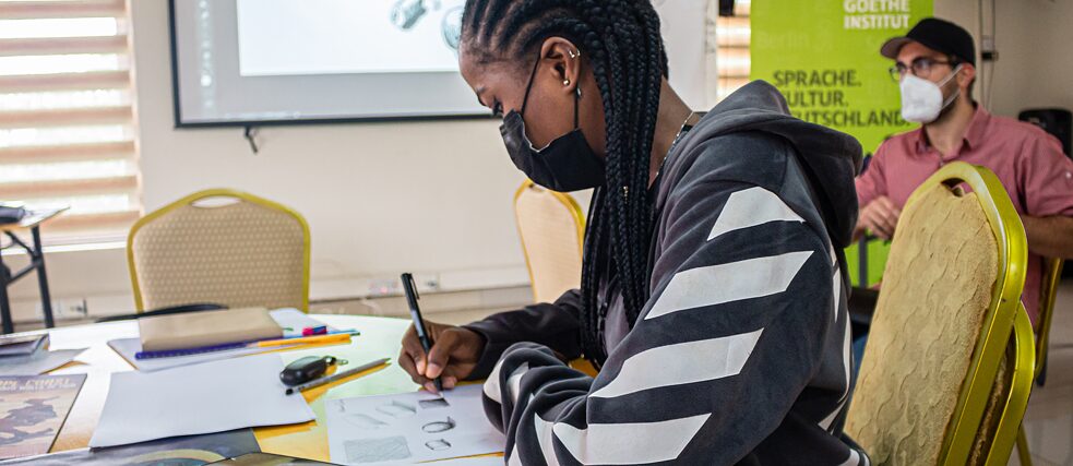 Un participant à l'atelier esquisse des formes.