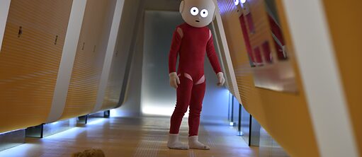 The picture shows a robot which is wearing red clothes and white socks. It has a big round head and round eyes. It is standing in a yellow and white corridor whose walls slope inwards.