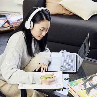 eine Frau mit Headset einem Laptop sitzend