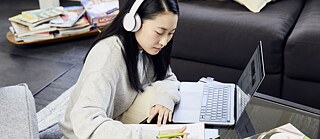 eine Frau mit Headset einem Laptop sitzend