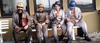 Gastarbeiter aus der Türkei sitzen nach ihrer Schicht auf einer Bank auf dem Gelände der Zeche Neu-Monopol in Bergkamen im Kreis Unna.