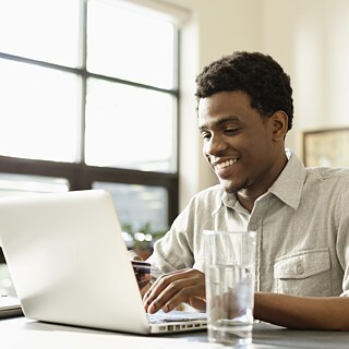 Mann vor einem aufgeklappten Laptop