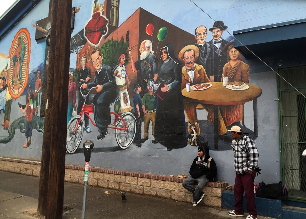 Dekolonisierung – El Paso, Texas: Anwohner stehen neben einem Wandbild mit historischen Chicano-Persönlichkeiten in dem Segundo Barrio-Viertel. 
