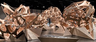 Im Berliner Futurium ließen die Künstler*innen von Art+Com eine mehrteilige Skulptur scheinbar organisch aus dem Boden wachsen, die einen acht Meter hohen Bogen im Raum schlägt: „Neo-Natur“.