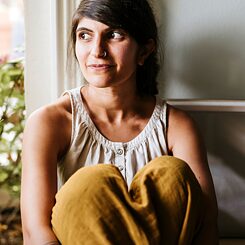 Forfatteren Shida Bazyar sidder i vindueskarmen og kigger ud af vinduet. 