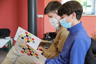 Zwei Schüler des Städtischen Max-Planck-Gymnasiums in Düsseldorf studieren das Programm der Abschlussveranstaltung