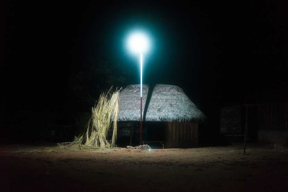 Una choza iluminada con lámparas de energía solar en la plaza central de Sarayaku.