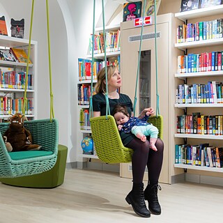 Mutter mit Kind in Bibliothek