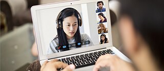 Frau vor Laptop sitzend in einer Videokonferenz