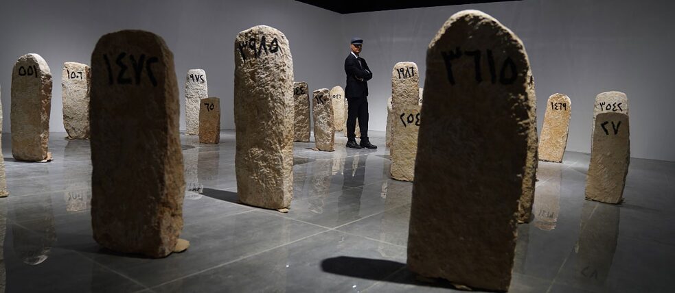 Der Künstler Ahmed Nabaz steht inmitten der, im Rahmen seiner Installationskunst, ausgestellten Grabsteine. 