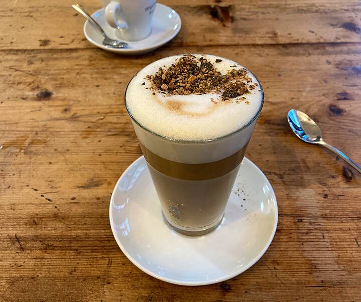 A glass of latte macchiato on a wooden table