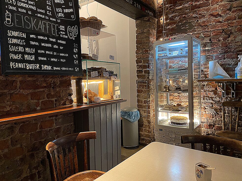 Café Rotkehlchen – man sieht eine Theke vor einer Backsteinwand, davor ein Tisch