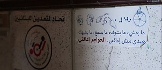 Image d'une affiche avec une écriture arabe ainsi qu'un symbole de fauteuil roulant, du braille et de la langue des signes