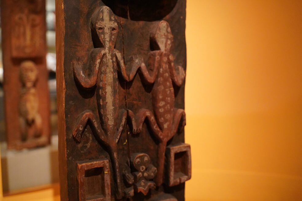 Two crocodile-shaped carvings in the foreground. A mirror in the background shows more carvings on the back.