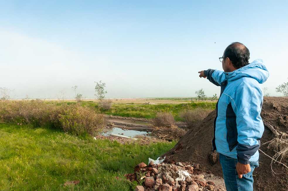 César del Valle señala la ubicación del paraje llamado “El Paraíso”. Al fondo, la barda perimetral del Nuevo Aeropuerto Internacional de México.