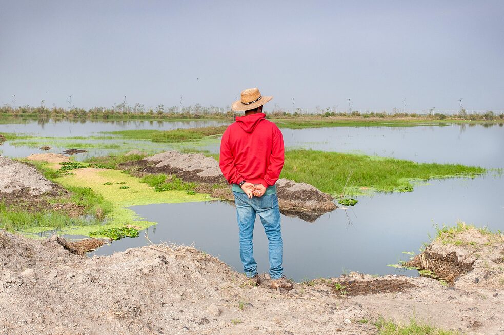 Daniel, ein Mitglieder der FPDT, betrachtet das Land und die Wasserlandschaften an den Ufern des Flusses Papalotla.