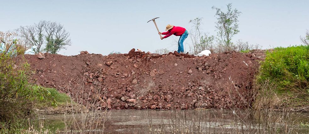 Daniel, ein Mitglied der FPDT, gräbt die Erde um, die für den Damm gebraucht wird. 