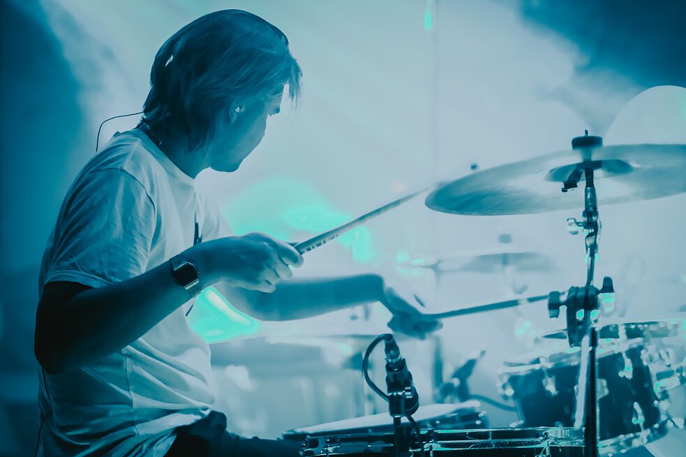 Ein junger Musiker, der ein Rockkonzert auf der Bühne gibt.